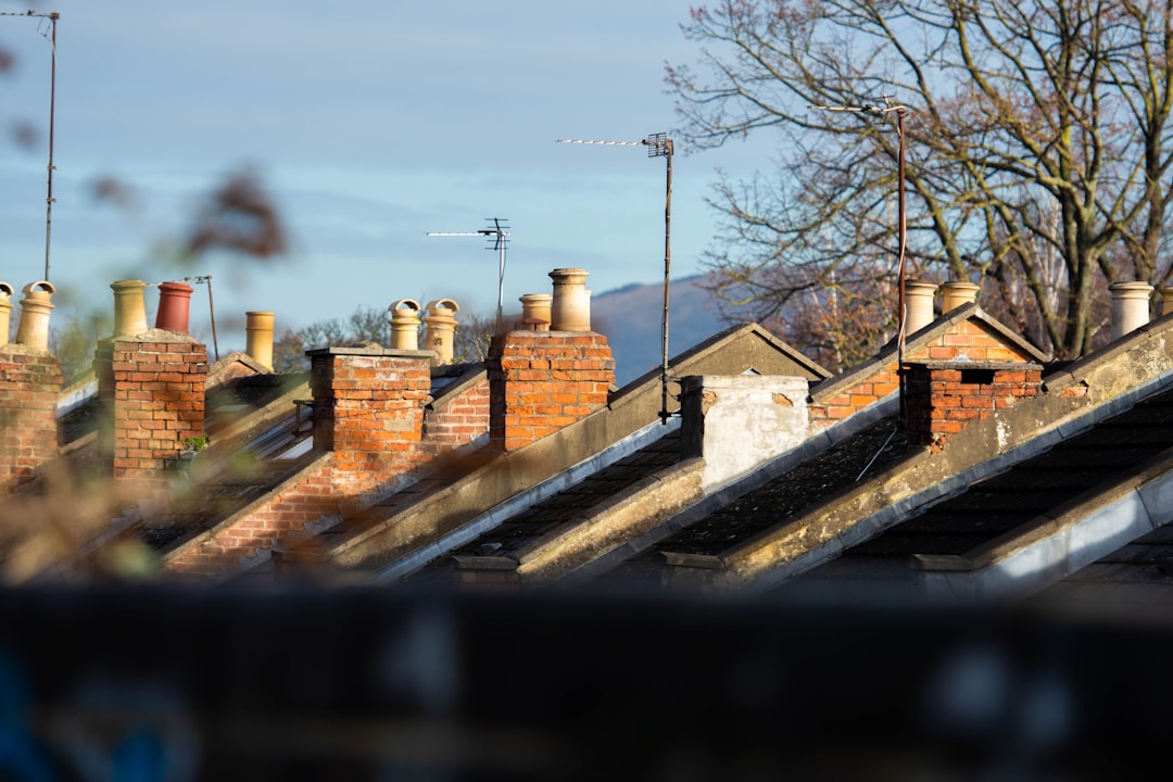 A row of brick chimneys along the roofline of a brick building